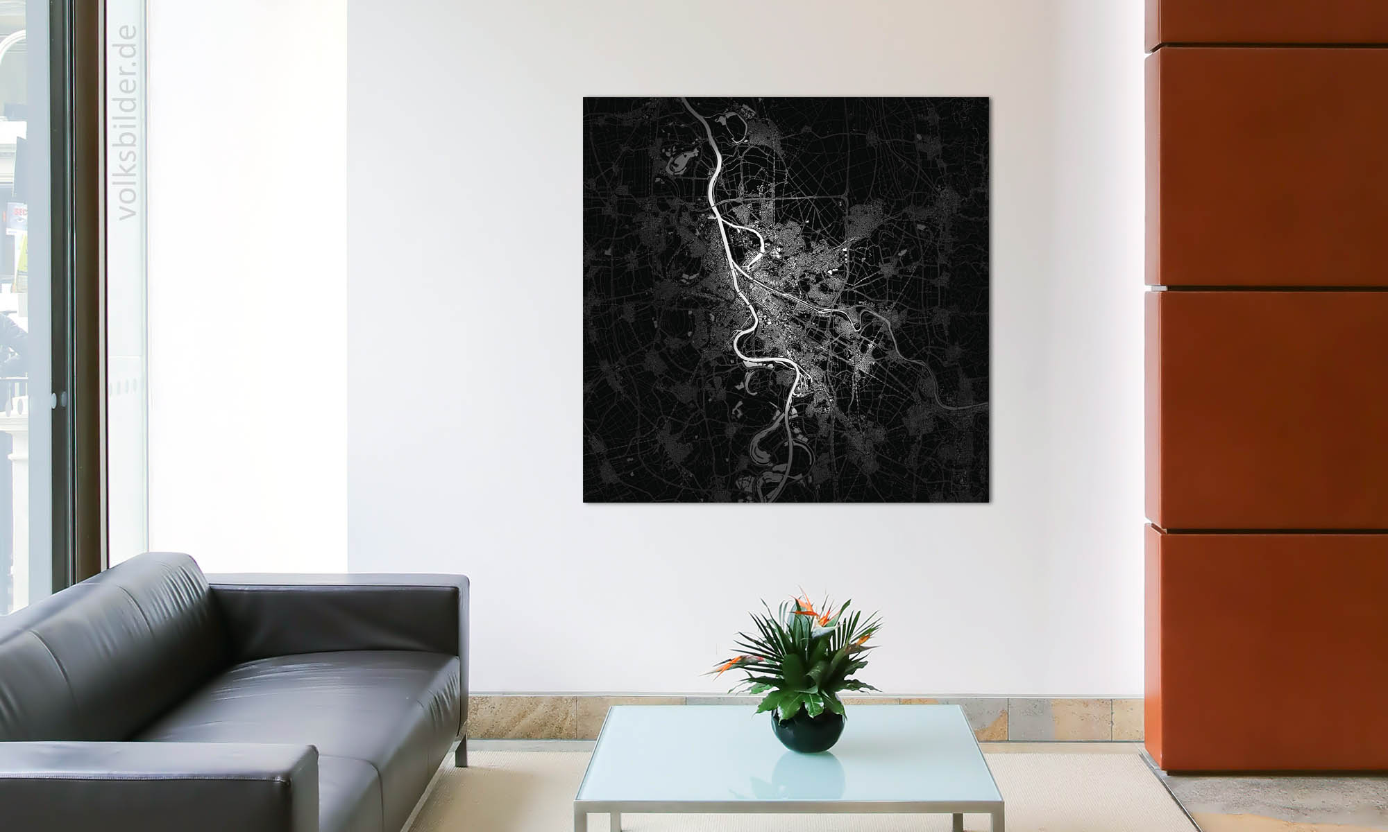 Das Foto zeigt ein Wartezimmer. Links steht eine schwarze Ledercouch, davor ein gläserner Couchtisch. An der Wand im Hintergrund hängt ein 
quadratisches Wandbild. Es zeigt eine schwarzweiße Karte vom Stadtgebiet von Mannheim und der näheren Umgebung.