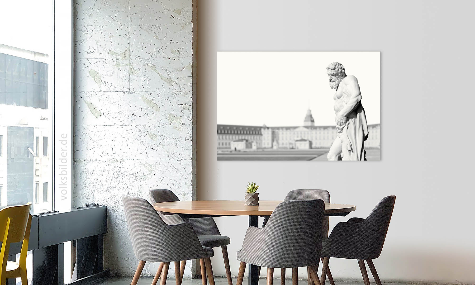 Das Foto zeigt ein Besprechungszimmer eines Büros. Im Vordergrund ein Tisch mit fünf sesselartigen Stühlen. An der Wand im Hintergrund hängt ein Wandbild mit einem High-Key-Foto der Statue des Herkules auf dem Schlossplatz vor dem Schloss in Karlsruhe.